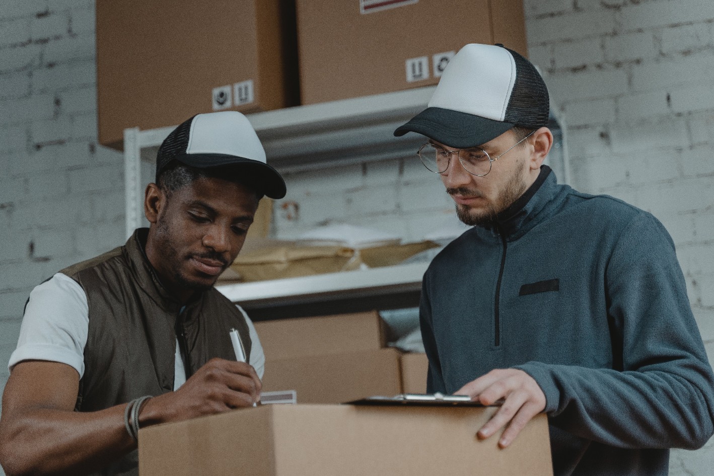 Two men prepare a box for moving